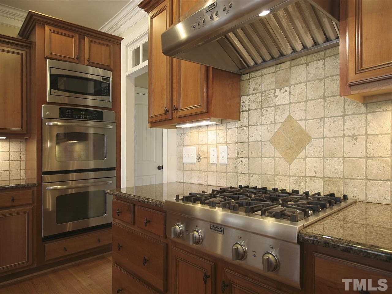 1205 Verde Farm Road Raleigh, NC 27603 - Photo 11 of 25 Gourmet stainless steel appliances include Thermador gas cooktop with hood, and GE wall ovens.