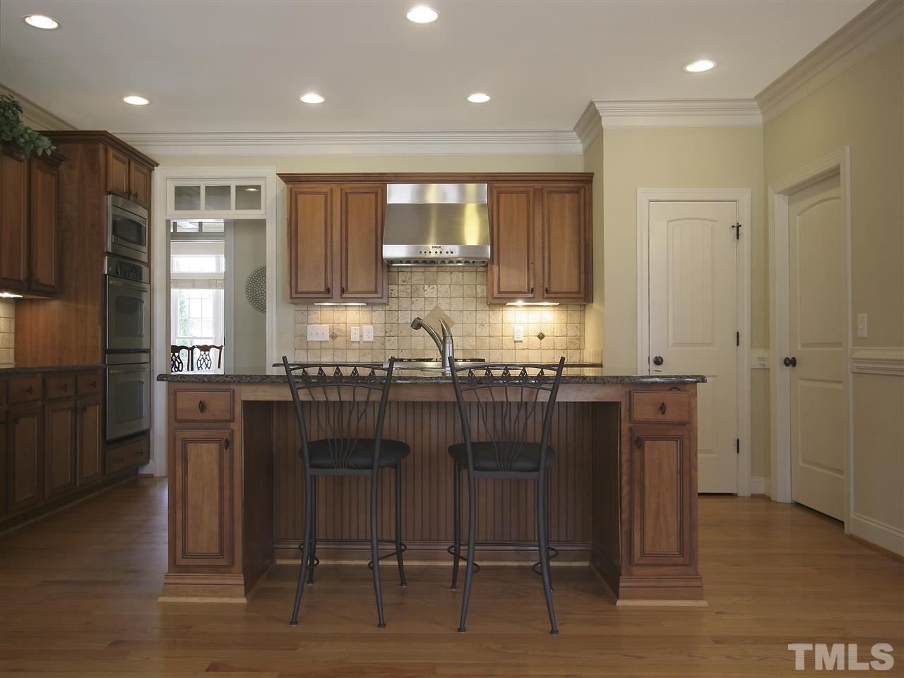 1205 Verde Farm Road Raleigh, NC 27603 - Photo 12 of 25 Kitchen has granite countertops, recessed and under-cabinet lighting, and custom tile backsplash. Crown molding. Pantry.