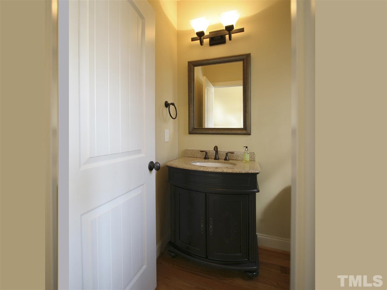1205 Verde Farm Road Raleigh, NC 27603 - Photo 17 of 25 Powder room has furniture-style vanity, framed mirror, and oil-rubbed bronze fixtures.