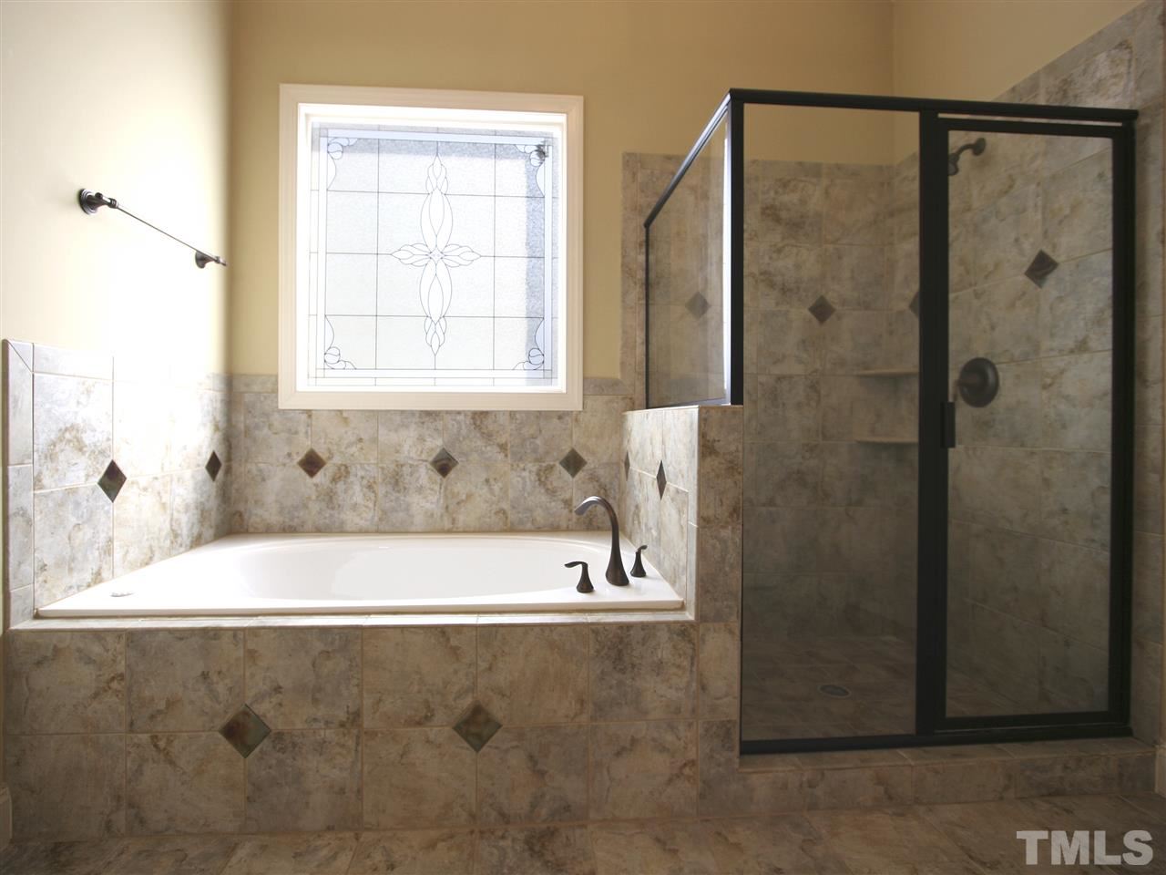 1205 Verde Farm Road Raleigh, NC 27603 - Photo 20 of 25 Luxurious master bath features large jetted tub with leaded-glass privacy window above. Separate shower with custom tile and oil-rubbed-bronze trim.