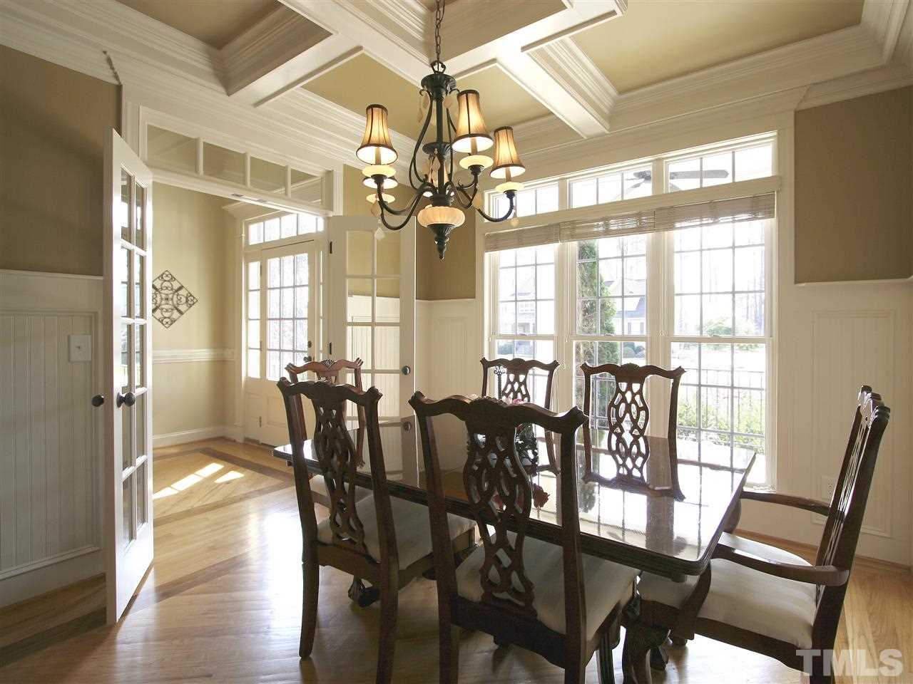 Entertain in style with this lovely formal dining room. Like a page from an architectural digest. Inlaid hardwood floor. Triple window with transom above. Tall recessed-panel beadboard wainscot.