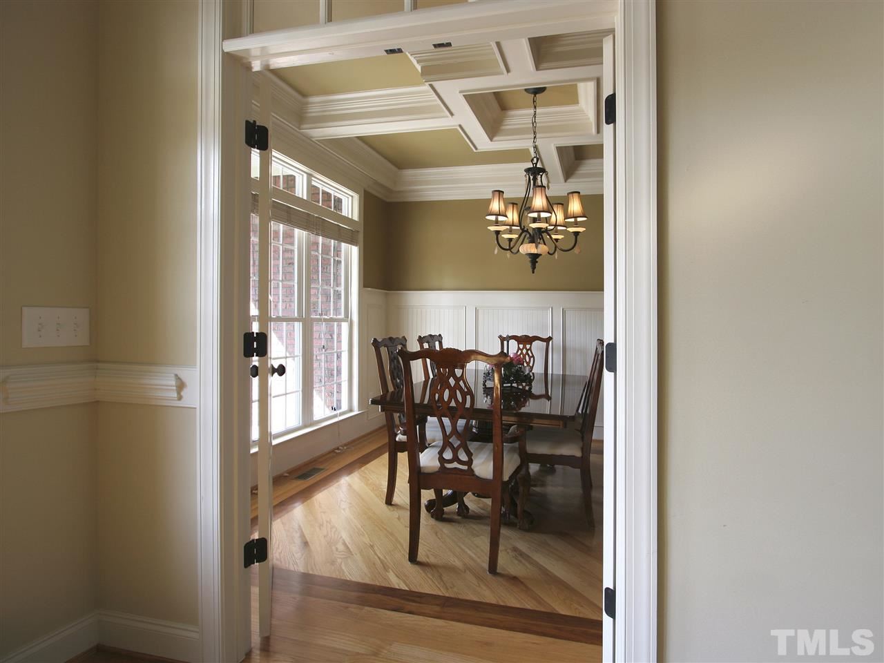 This view of the dining room from the foyer showcases the stunning coffered ceiling and inlaid hardwood floor.