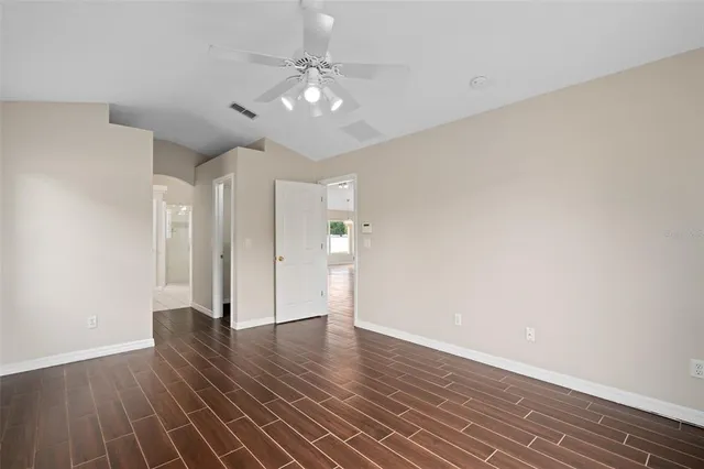 an empty room with a window and a ceiling fan