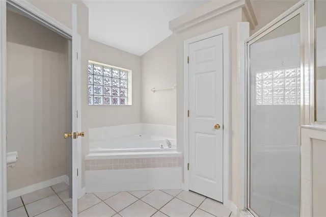 an empty room with windows and ceiling fan