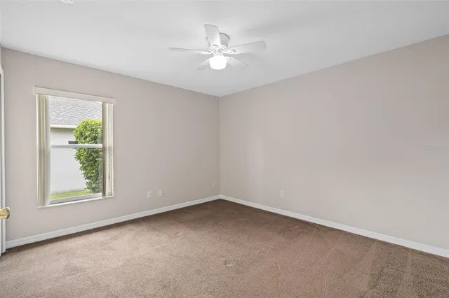 a view of a livingroom with a ceiling fan and window