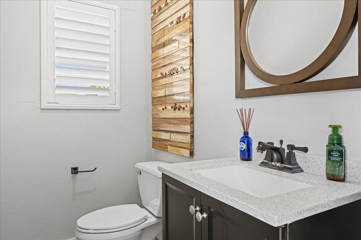 1502 Reimer Street Brenham, TX 77833 - Photo 27 of 30 a bathroom with a sink a toilet and a mirror