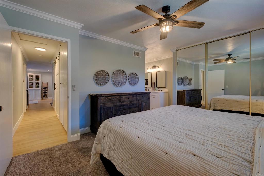 8942 Fletcher Valley Dr. Santee, CA 92071 - Photo 22 of 32 a bedroom with a bed and a chandelier