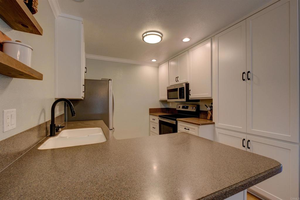 8942 Fletcher Valley Dr. Santee, CA 92071 - Photo 10 of 32 a kitchen with stainless steel appliances a sink and a refrigerator