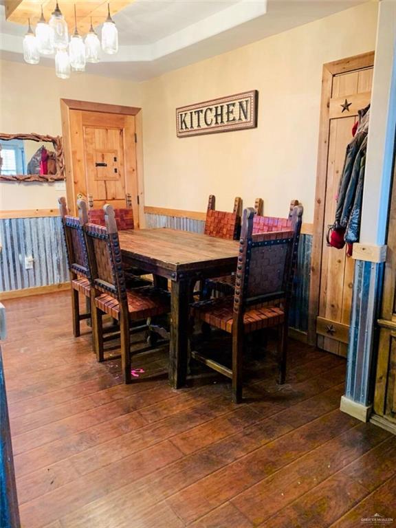 2938 Highway 83 Roma, TX 78584 - Photo 8 of 23 Dining area with a tray ceiling, wainscoting, and hardwood / wood-style floors