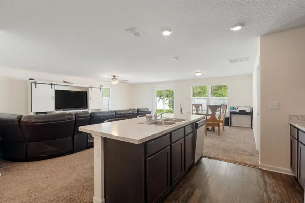 a room with furniture a flat screen tv and a refrigerator