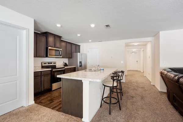 a kitchen with a sink a counter top space stainless steel appliances and cabinets