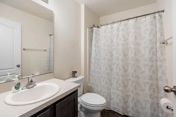 a bathroom with a sink toilet and a mirror