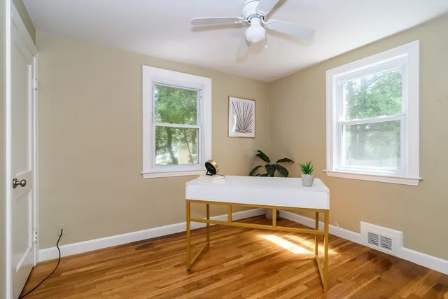 a view of a workspace with wooden floor and a window