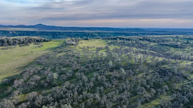 a view of mountain with sunset in background