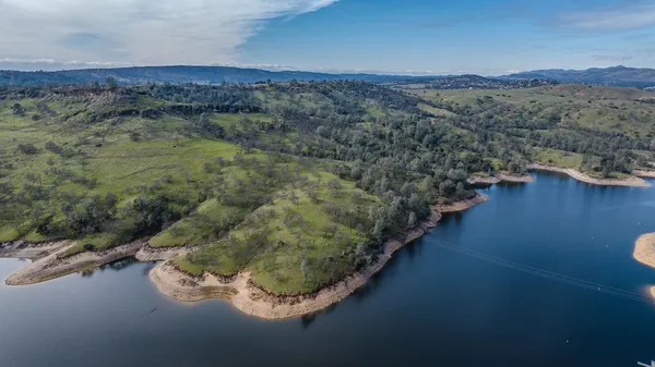 a view of a lake with mountain and trees all around