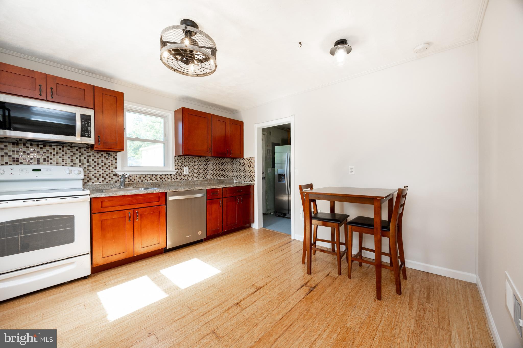 2405 Line Lexington Road Hatfield, PA 19440 - Photo 15 of 31 a kitchen with stainless steel appliances granite countertop a stove top oven a sink a dining table and chairs with wooden floor