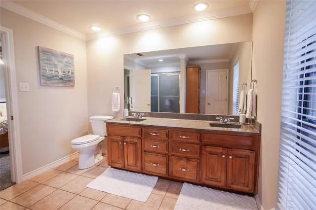 a bedroom with a bed a chandelier and a window