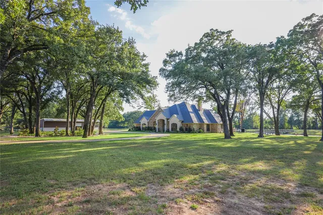 a front view of a house with a yard and trees