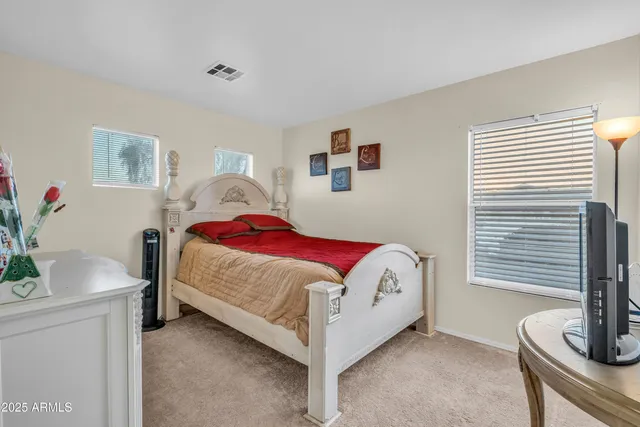a bedroom with a bed and a potted plant