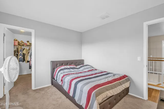 a bedroom with a bed and painting on the wall