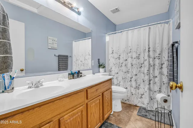 a bathroom with a sink toilet double vanity and shower