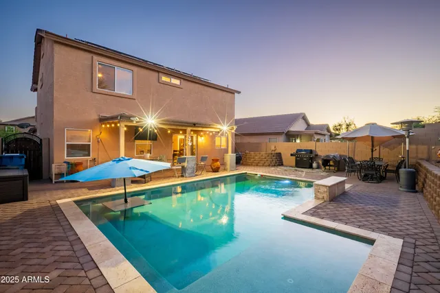 a view of a house with swimming pool and furniture