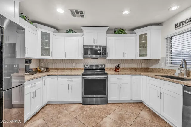 a kitchen with stainless steel appliances granite countertop a stove sink and cabinets