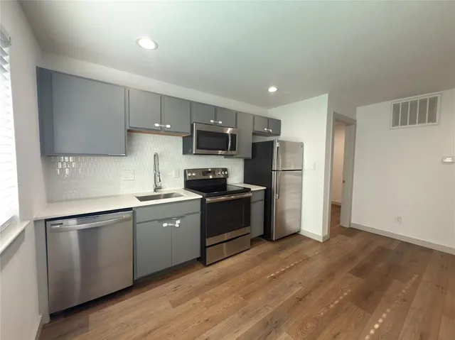 a kitchen with a refrigerator a sink a stove a microwave and cabinets