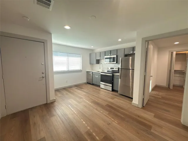 a kitchen with stainless steel appliances granite countertop a refrigerator and a stove top oven