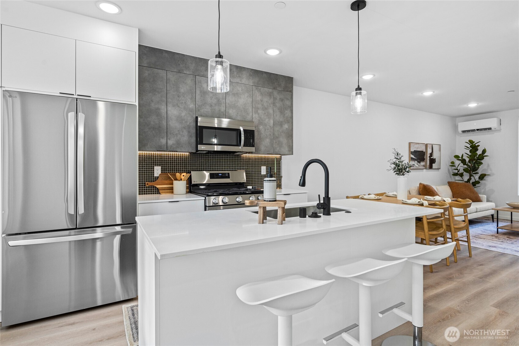 3510 Northeast 125th Street, Unit F Seattle, WA 98125 - Photo 17 of 24 a kitchen with stainless steel appliances granite countertop a refrigerator a sink a stove and a refrigerator with wooden floor