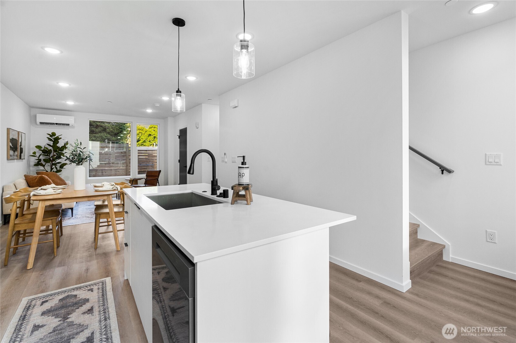3510 Northeast 125th Street, Unit F Seattle, WA 98125 - Photo 18 of 24 a kitchen with stainless steel appliances granite countertop a sink a stove and a dining table with wooden floor