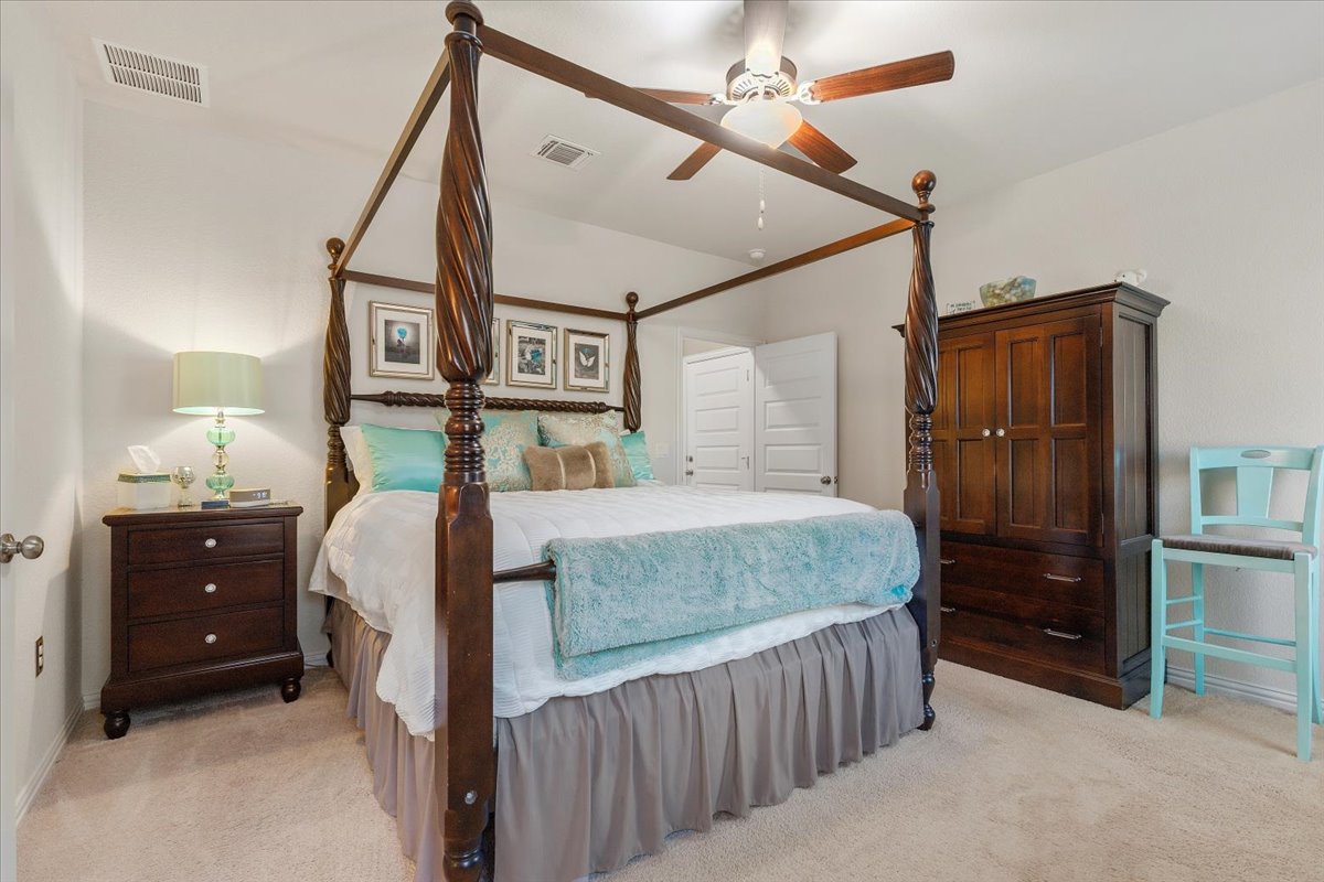 8721 Sikes Way Austin, TX 78747 - Photo 16 of 37 Bedroom featuring light carpet and ceiling fan