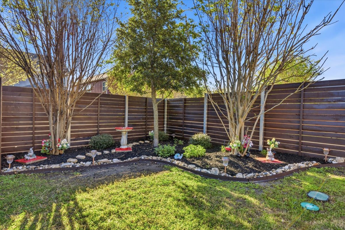8721 Sikes Way Austin, TX 78747 - Photo 30 of 37 a view of a backyard with plants and a tree