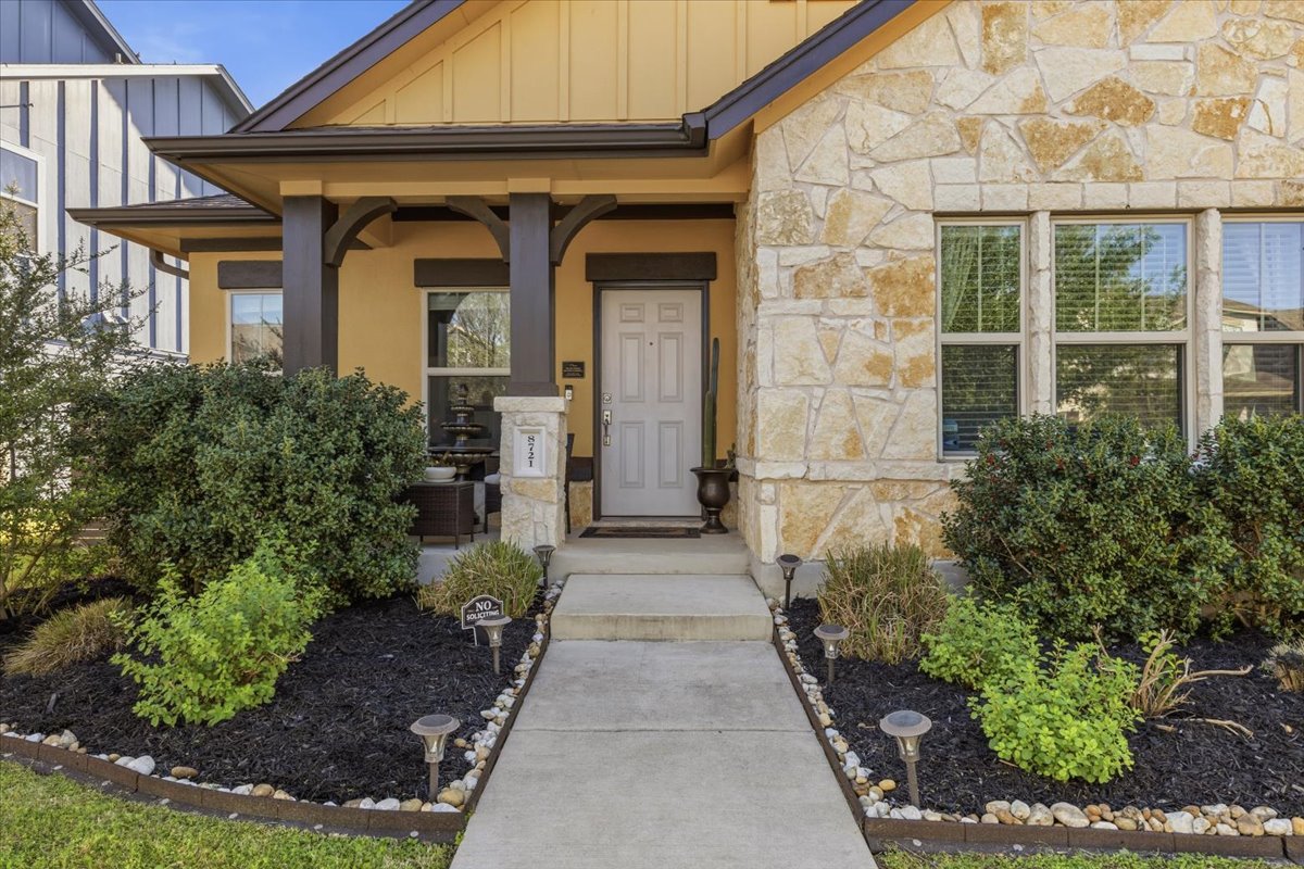 8721 Sikes Way Austin, TX 78747 - Photo 5 of 37 Property entrance featuring stone siding, board and batten siding, and a porch