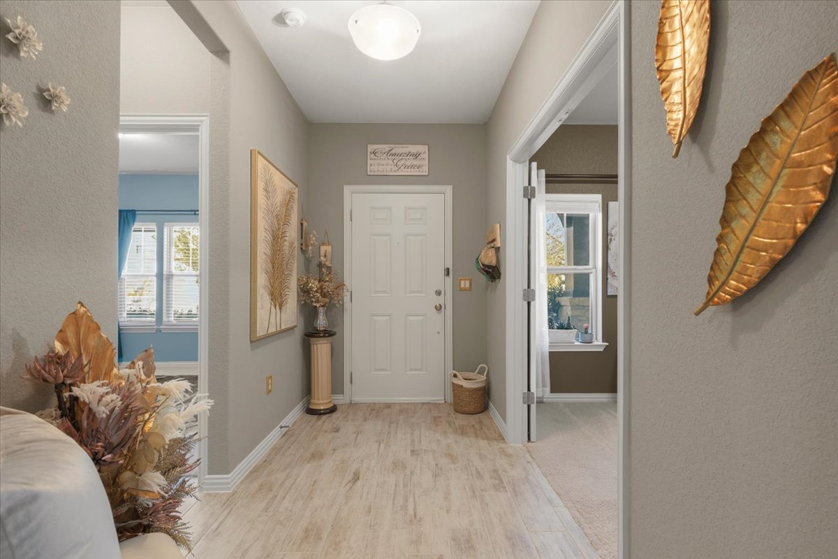 8721 Sikes Way Austin, TX 78747 - Photo 6 of 37 Foyer entrance with light wood-style flooring and a textured wall