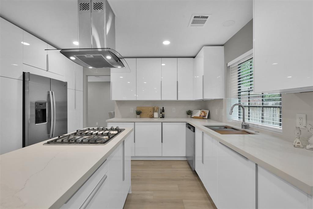 a kitchen with stainless steel appliances kitchen island a sink stove and refrigerator
