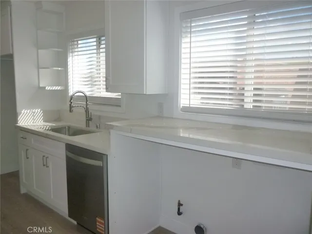 a kitchen with a sink cabinets and a window