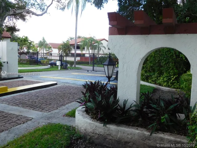a view of a yard in front of a house with a fountain