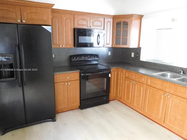 a kitchen with stainless steel appliances granite countertop a refrigerator stove and sink