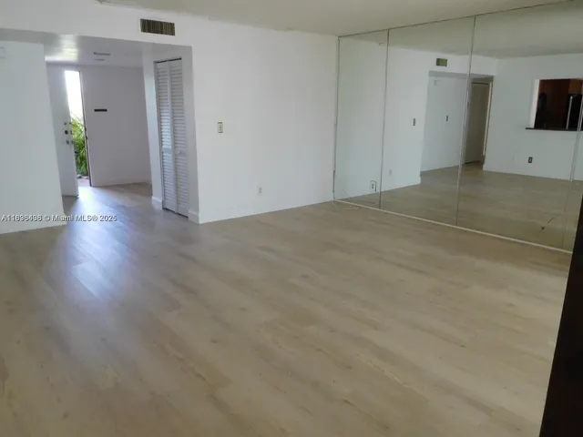 a view of a room with wooden floor