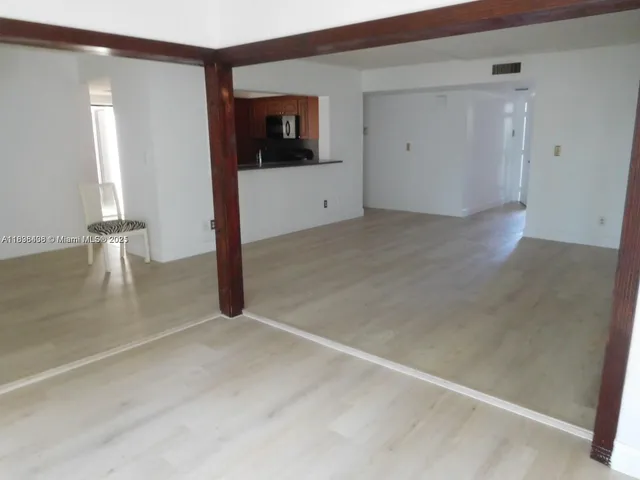 an empty room with wooden floor and mirror