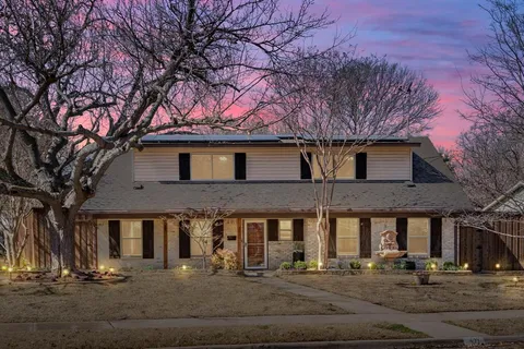 a front view of house with a tree