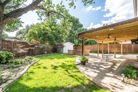 a view of a patio with table and chairs and wooden fence