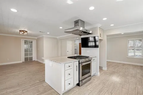 a kitchen with stainless steel appliances kitchen island granite countertop a stove sink and microwave