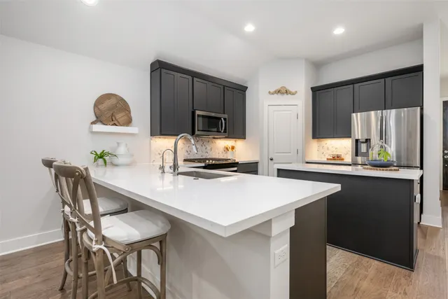 a kitchen with a table chairs refrigerator and microwave