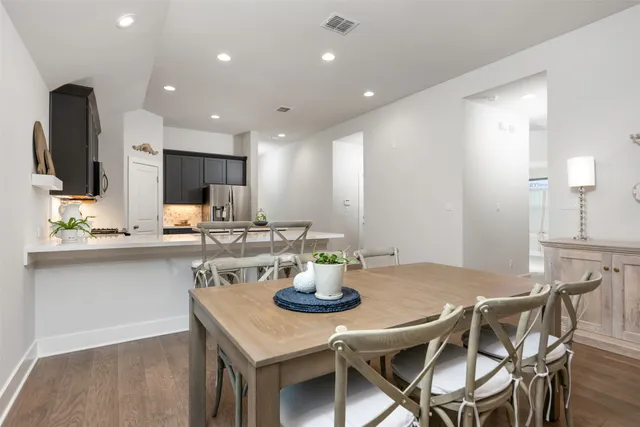 a kitchen with stainless steel appliances kitchen island granite countertop a table and chairs in it