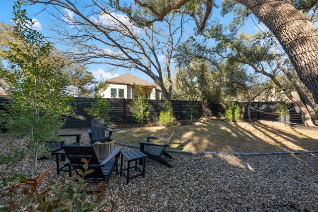 a view of a house with backyard and trees