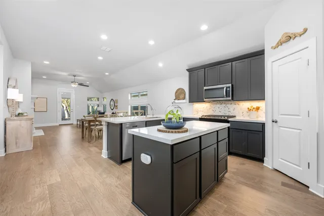 a kitchen that has a lot of cabinets in it and wooden floors