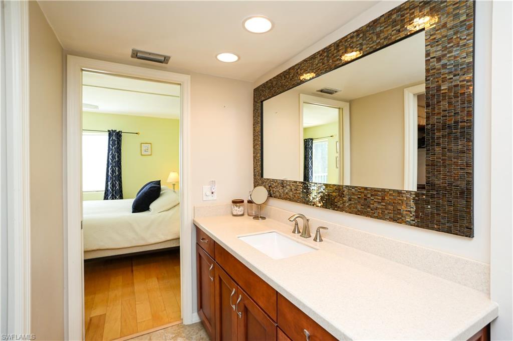 1075 Foxfire Lane, Unit 207 Naples, FL 34104 - Photo 14 of 26 a en suite bathroom with a double vanity sink and a mirror