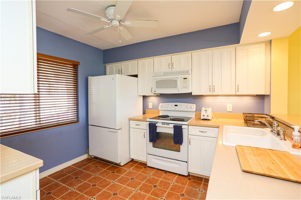 1075 Foxfire Lane, Unit 207 Naples, FL 34104 - Photo 3 of 26 a kitchen with stainless steel appliances granite countertop a refrigerator sink and stove